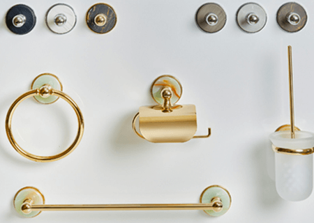 Una colección de accesorios de baño dorados sobre una superficie blanca.
